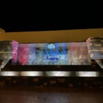 Resort welcome sign looks drab during daylight but very colorful during the evening